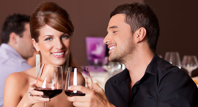 Love Stories - happy couple at restaurant table toasting